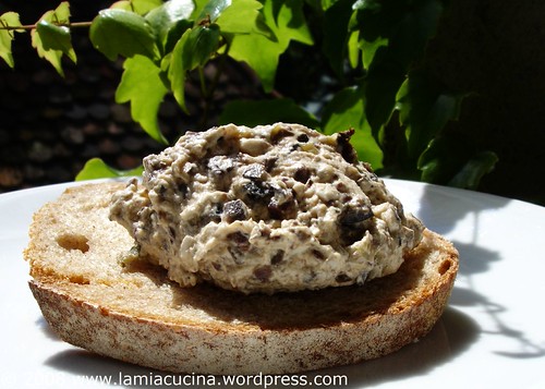 Olivenmousse auf Brot im Schatten einer Wildrebe